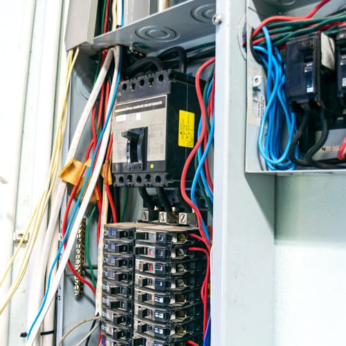 This image showcases a detailed view of an electrical circuit breaker panel, featuring various wires and connections that demonstrate installation and maintenance practices.