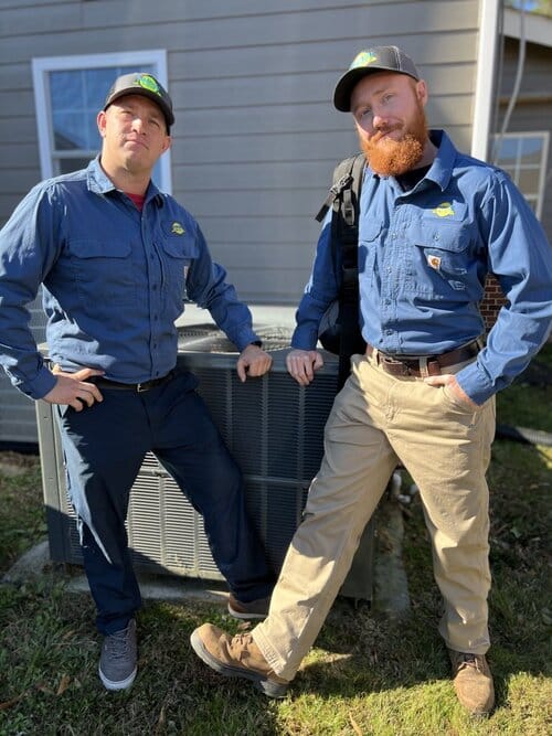 AC technicians in front of an air conditioner compressor