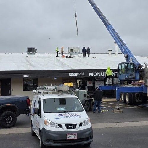 workers repairing HVAC on a commercial building