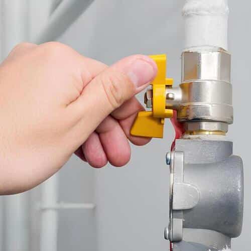 hand turning a gas line valve