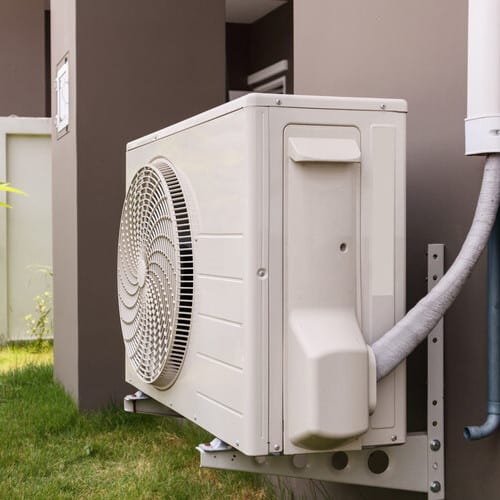 heat pump system installed against a wall